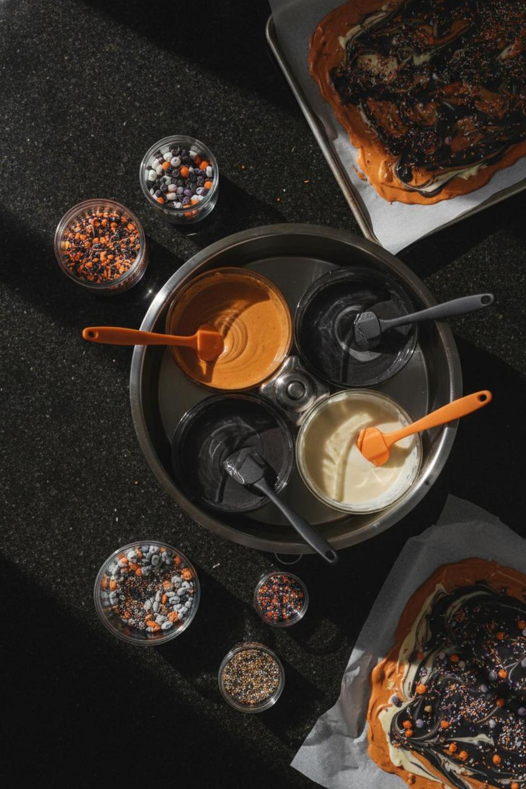 Halloween bark ingredients and tools for easy halloween candy bark recipes flat-lay with melting wafers and sprinkles
